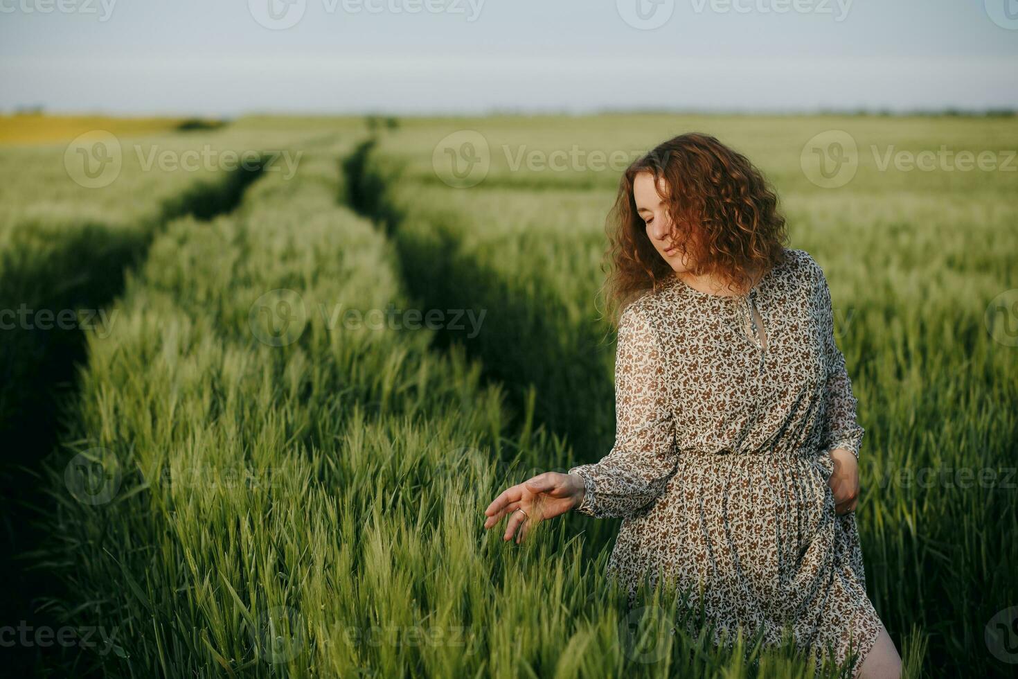 encaracolado menina em pé em a campo foto