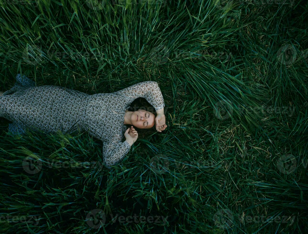 jovem menina deitado em verde trigo campo foto