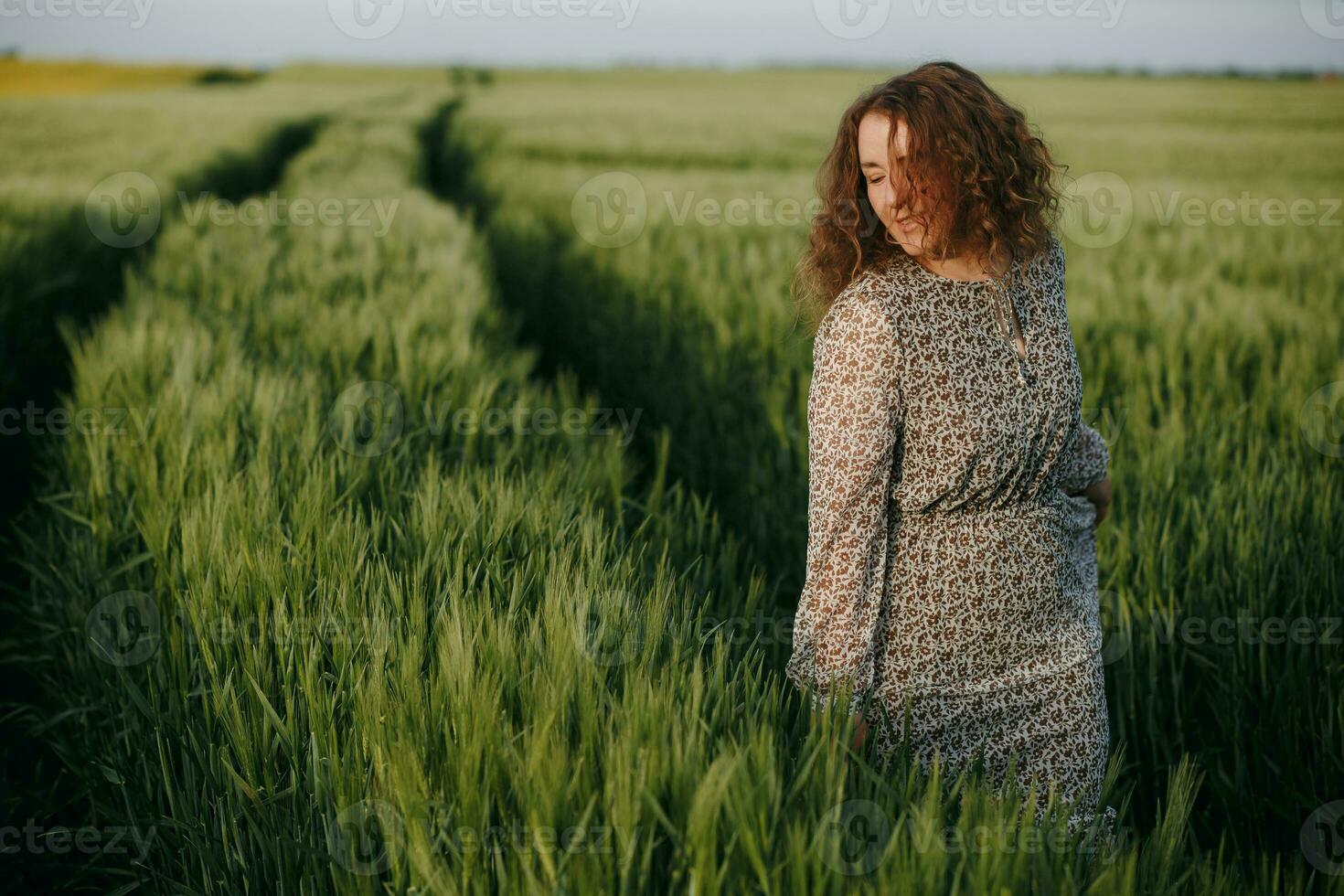 encaracolado menina em pé em verde campo foto