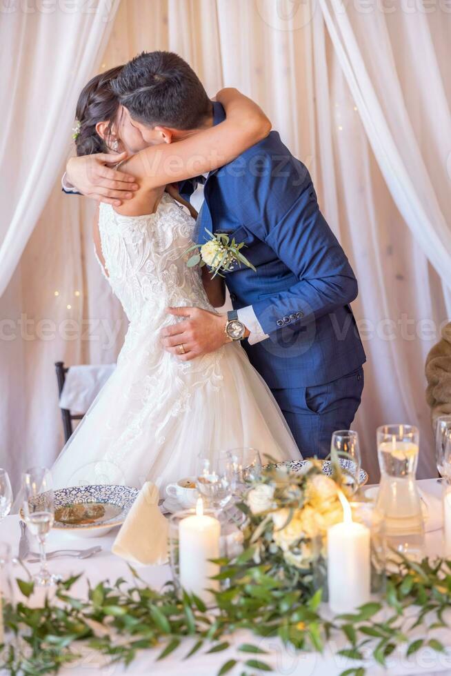recém-casados executar uma apaixonado beijo dentro frente do Casamento convidados em seus especial dia foto