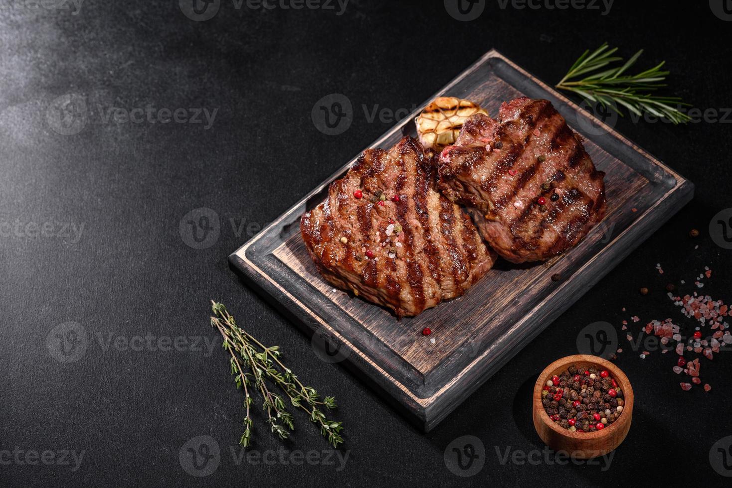 Bife fresco suculento delicioso em um fundo escuro foto