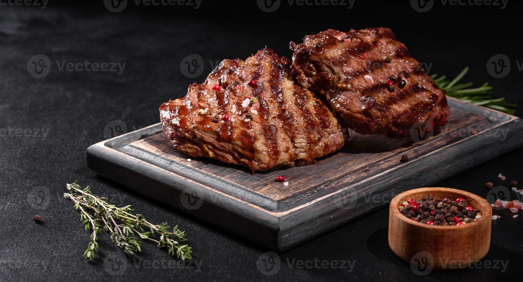 Bife fresco suculento delicioso em um fundo escuro foto