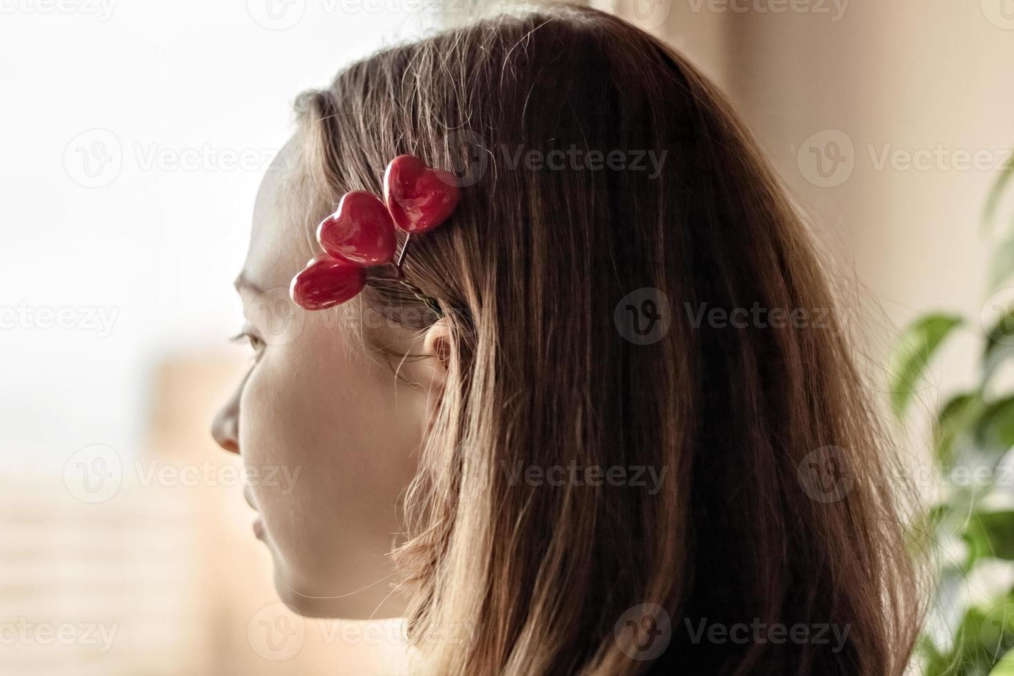 retrato de uma linda garota triste olhando pela janela com esperança e expectativa foto