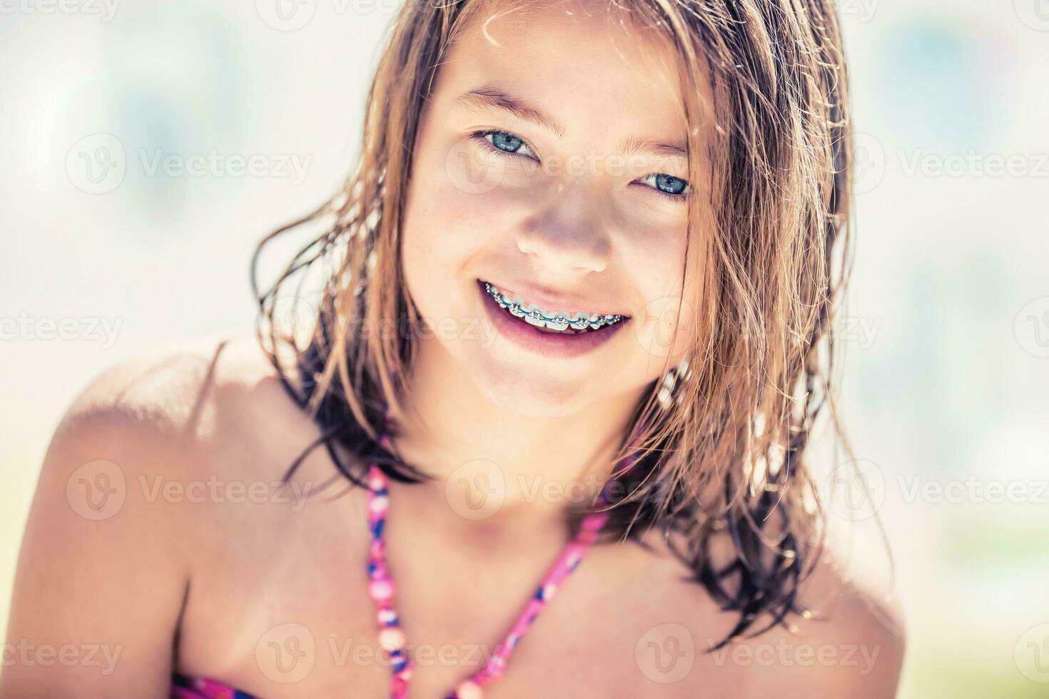 menina com dentes aparelho ortodôntico. bonita jovem adolescente menina com dental aparelho ortodôntico. retrato do uma fofa pequeno menina em uma ensolarado dia dentro bikini foto