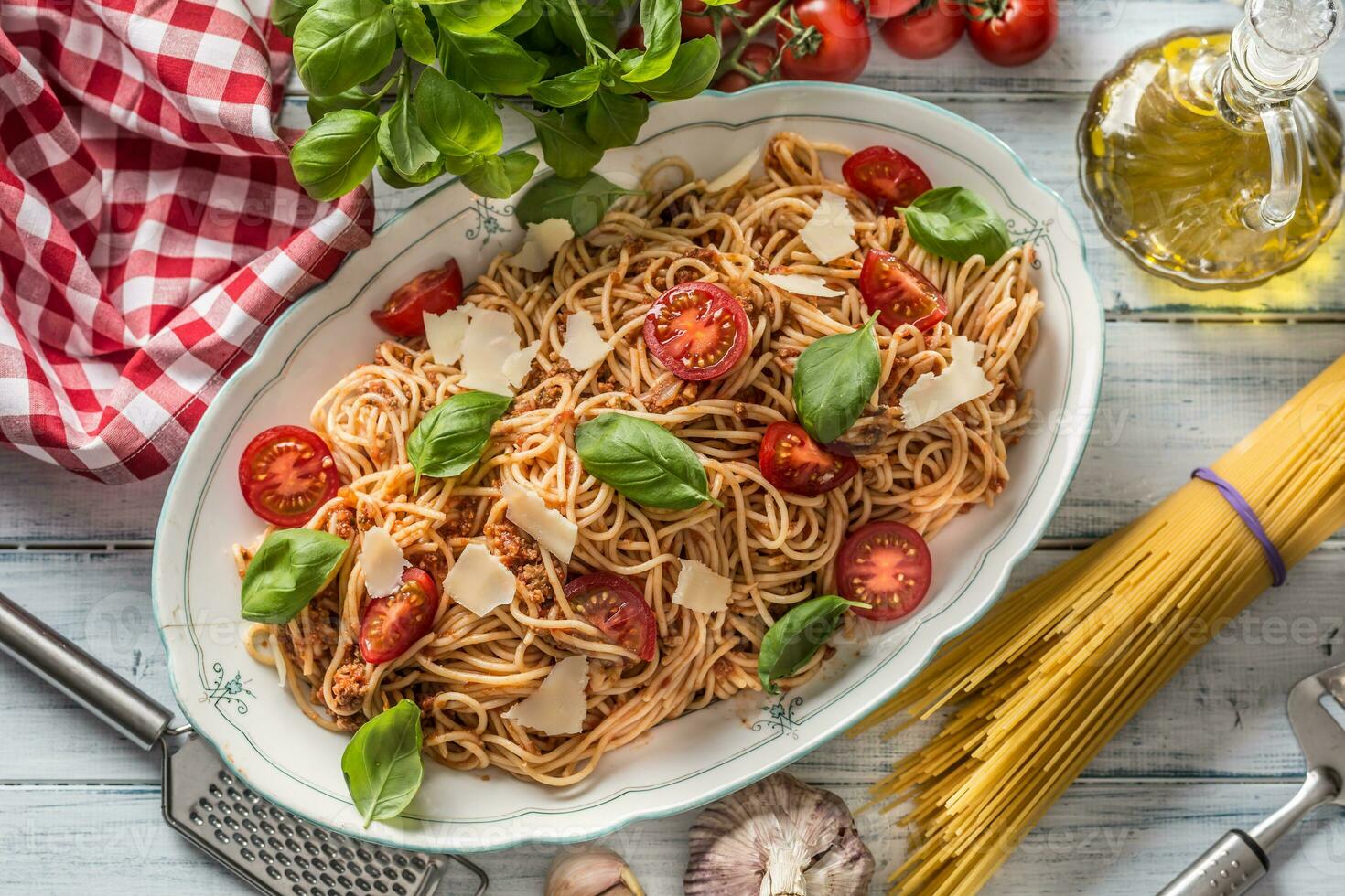 italiano massa espaguete bolonhesa dentro branco tigela com tomates parmesão queijo e manjericão foto