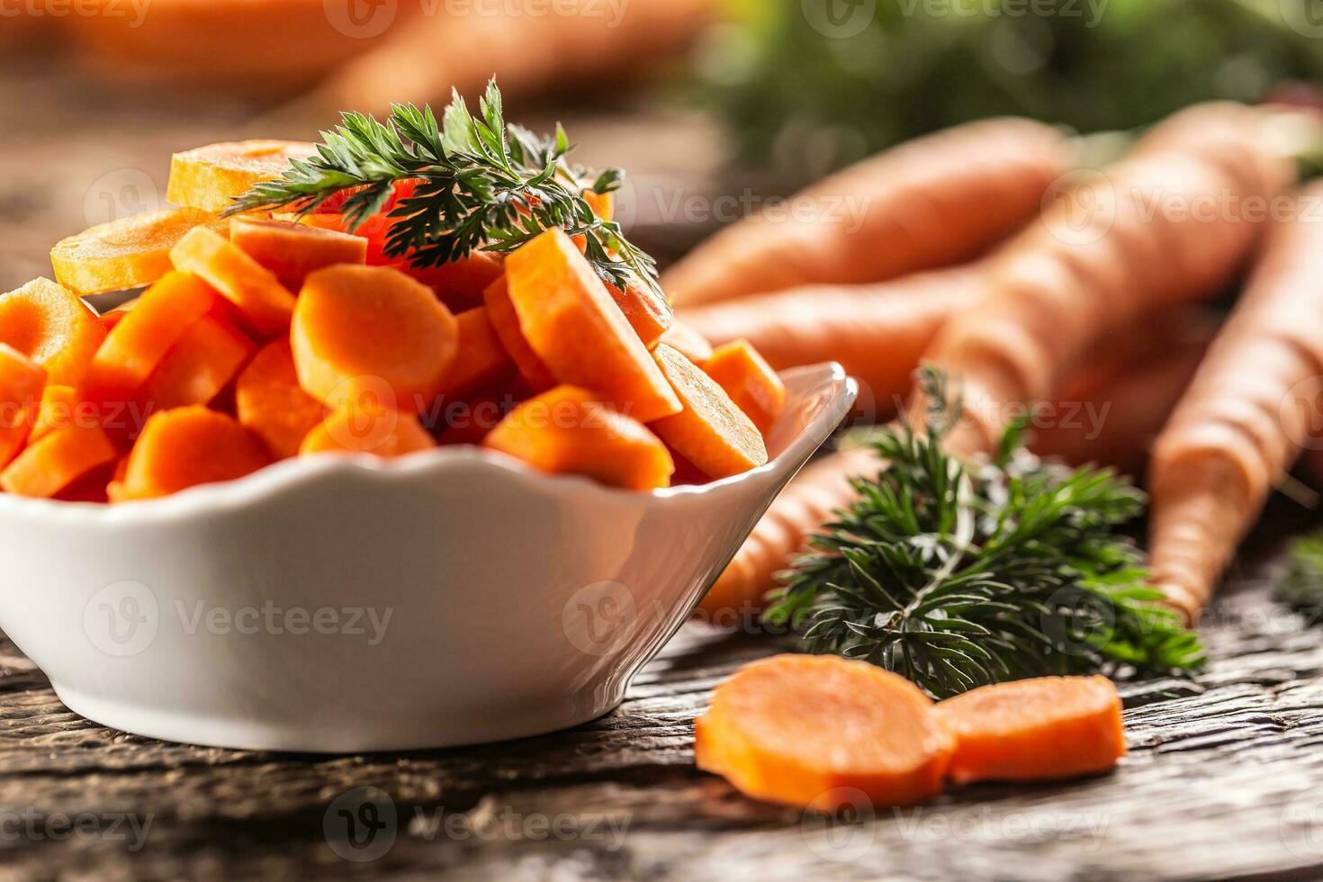 fatiado peças do cenoura dentro uma tigela e uma fresco grupo do cenouras dentro a fundo foto