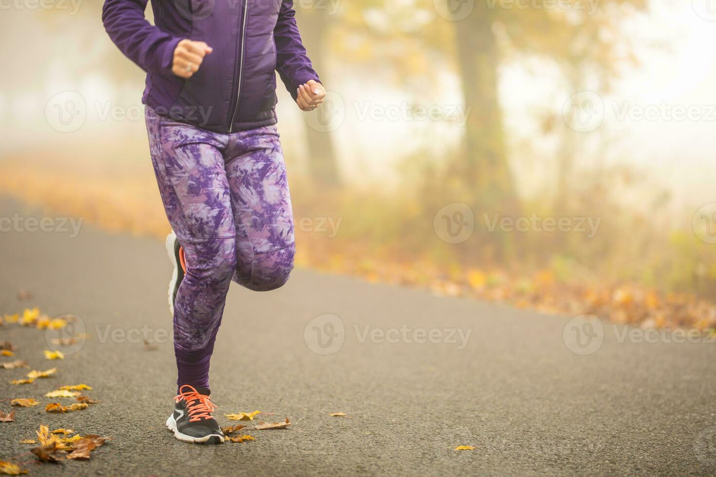 fechar-se Visão do fêmea pernas corrida dentro outono natureza foto