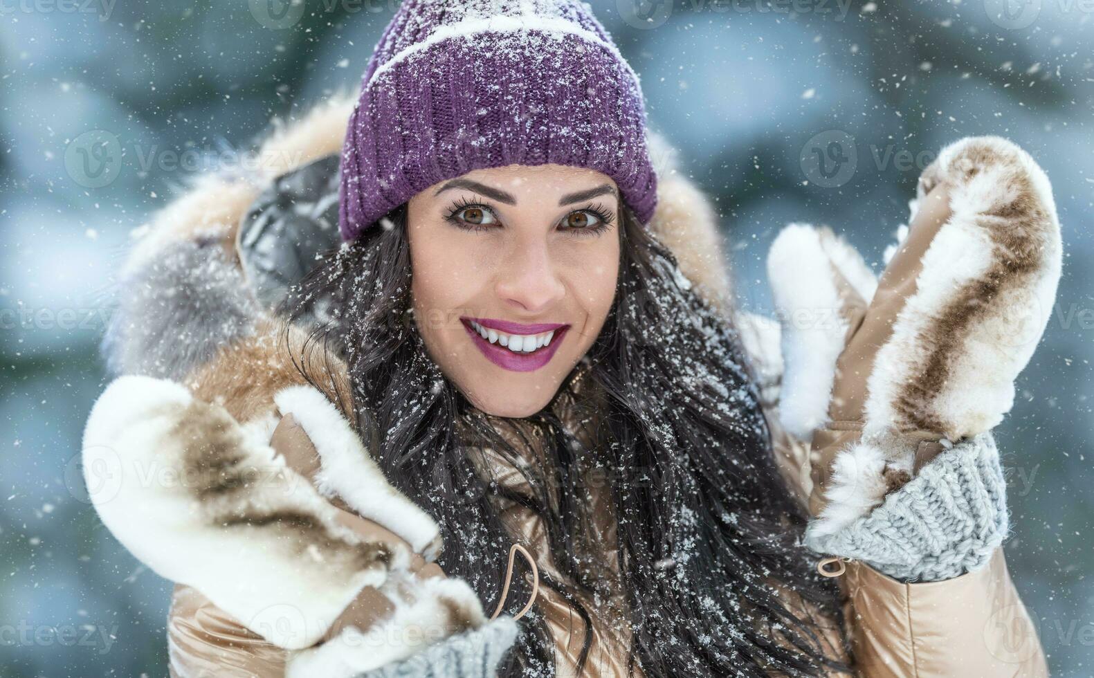 lindo moda amoroso mulher desgasta pele casaco e peludo luvas ao ar livre em uma Nevado dia foto