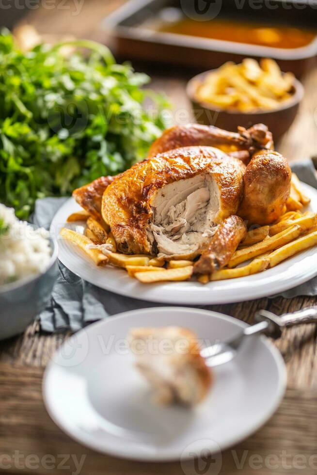 todo assado frango cortar em uma garfo com lado pratos arroz e francês fritas foto