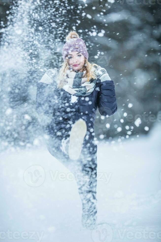 jovem mulher dentro caloroso roupas é tendo Diversão Fora do a neve foto