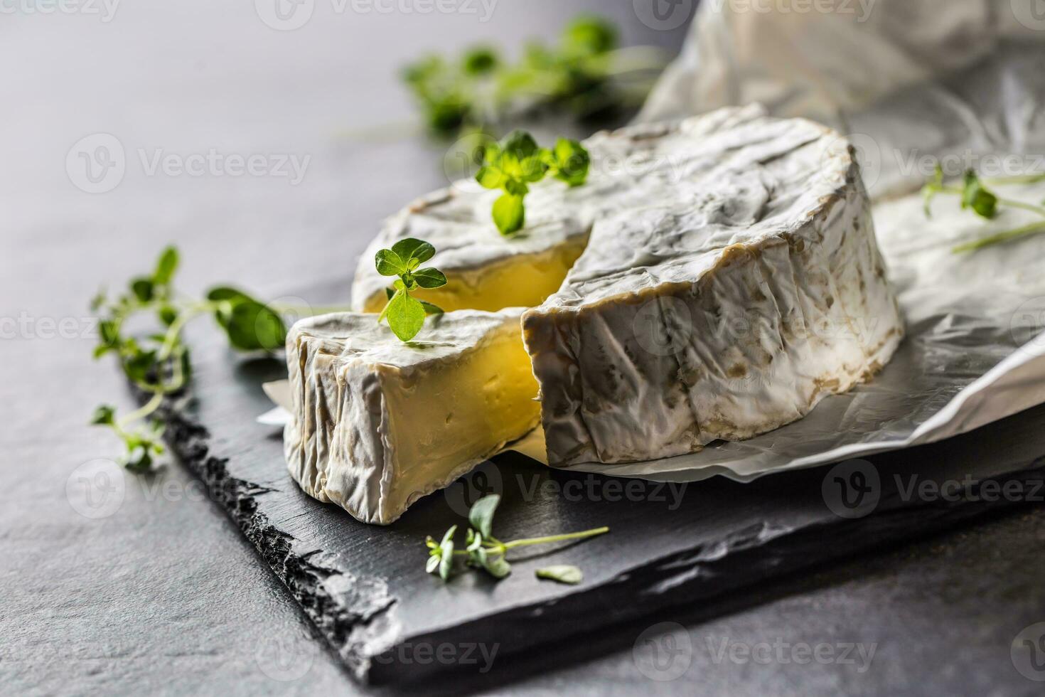 queijo camambert a partir de orégano ervas em ardósia borda foto