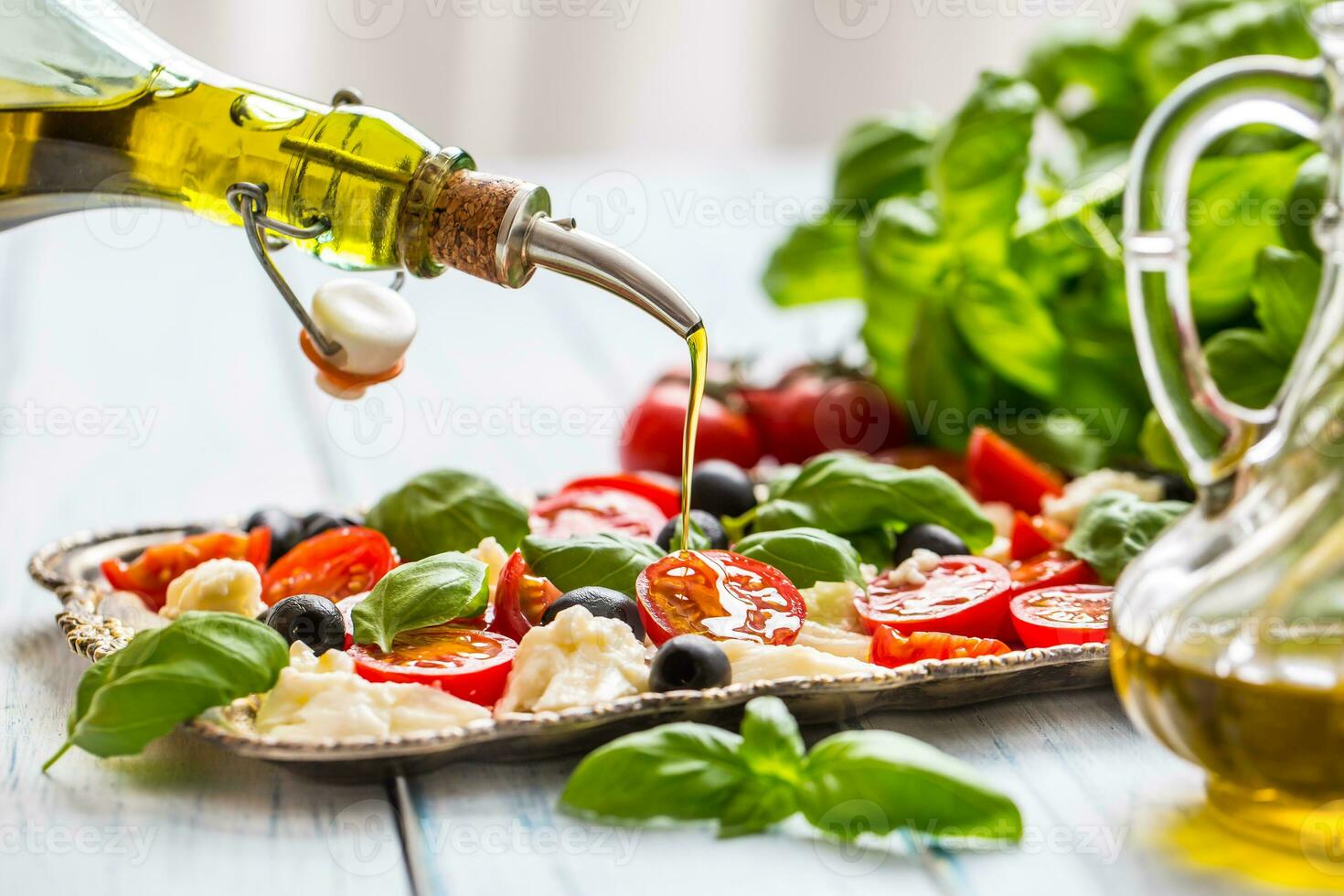 derramando Oliva óleo em caprese salada. saudável italiano ou Mediterrâneo refeição foto
