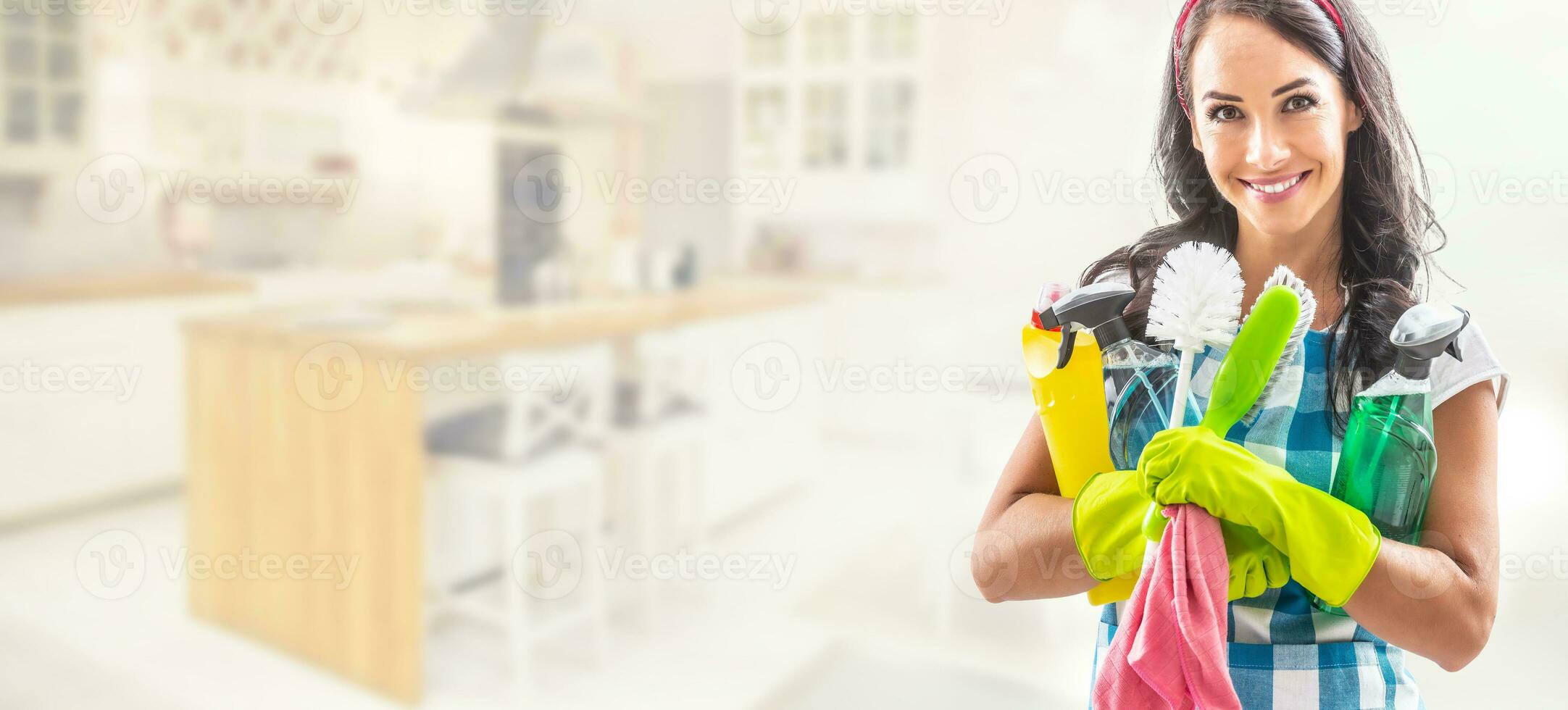 bonito mulher em pé dentro a certo terceiro do uma cenário com uma cozinha dentro a fundo segurando limpeza coisa dentro dela braços foto