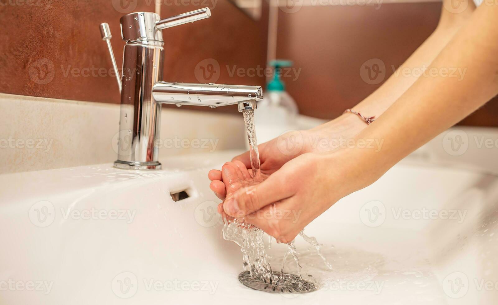 lavando mãos com água e líquido Sabonete dentro a banheiro foto