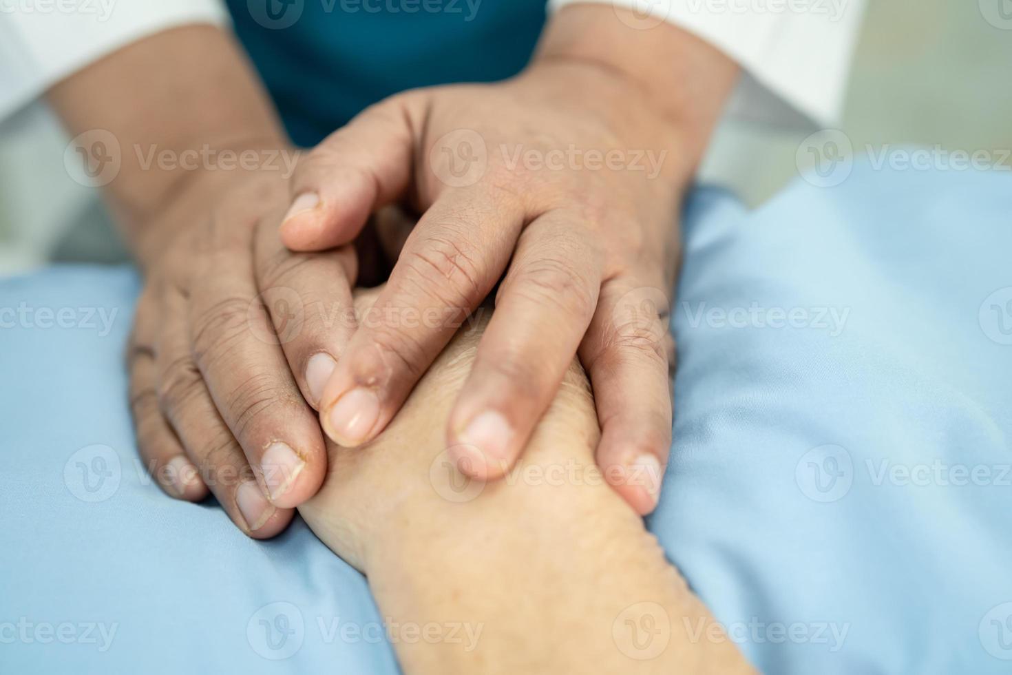 médico segurando mãos comoventes paciente idosa asiática sênior ou idosa com amor, carinho, ajuda, incentivo e empatia na enfermaria do hospital de enfermagem, conceito médico forte e saudável foto