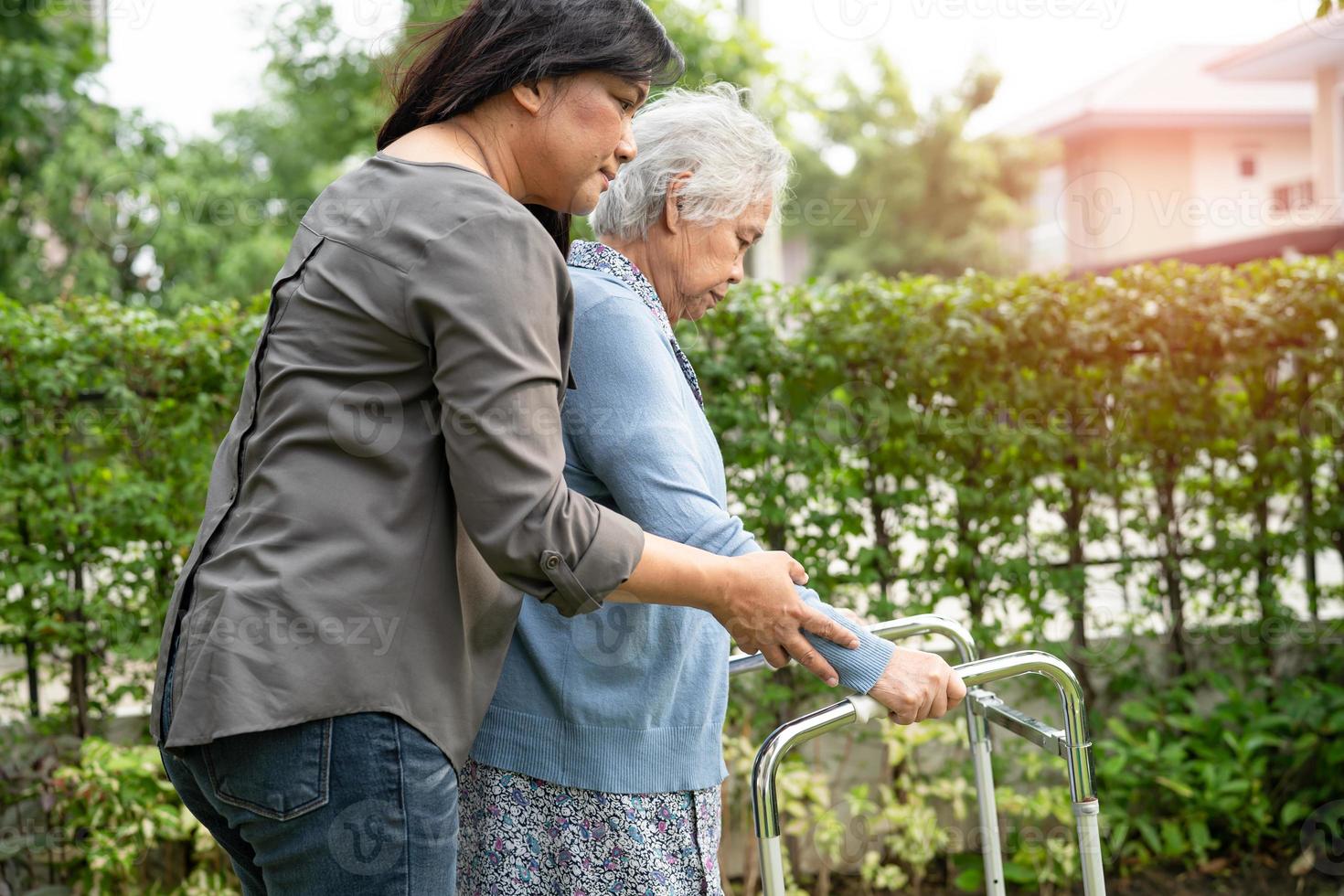 ajuda e cuidado mulher idosa asiática sênior ou idosa usar walker com forte saúde enquanto caminhava no parque em feliz feriado fresco. foto