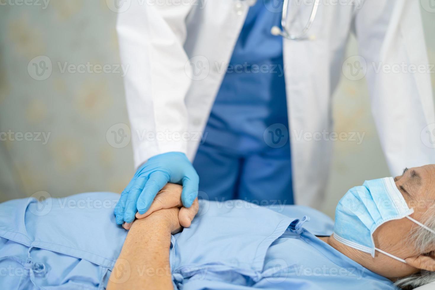 médico asiático vestindo terno novo normal para verificar paciente com máscara proteger surto de coronavírus covid-19 de infecção de segurança na enfermaria de quarentena do hospital. foto