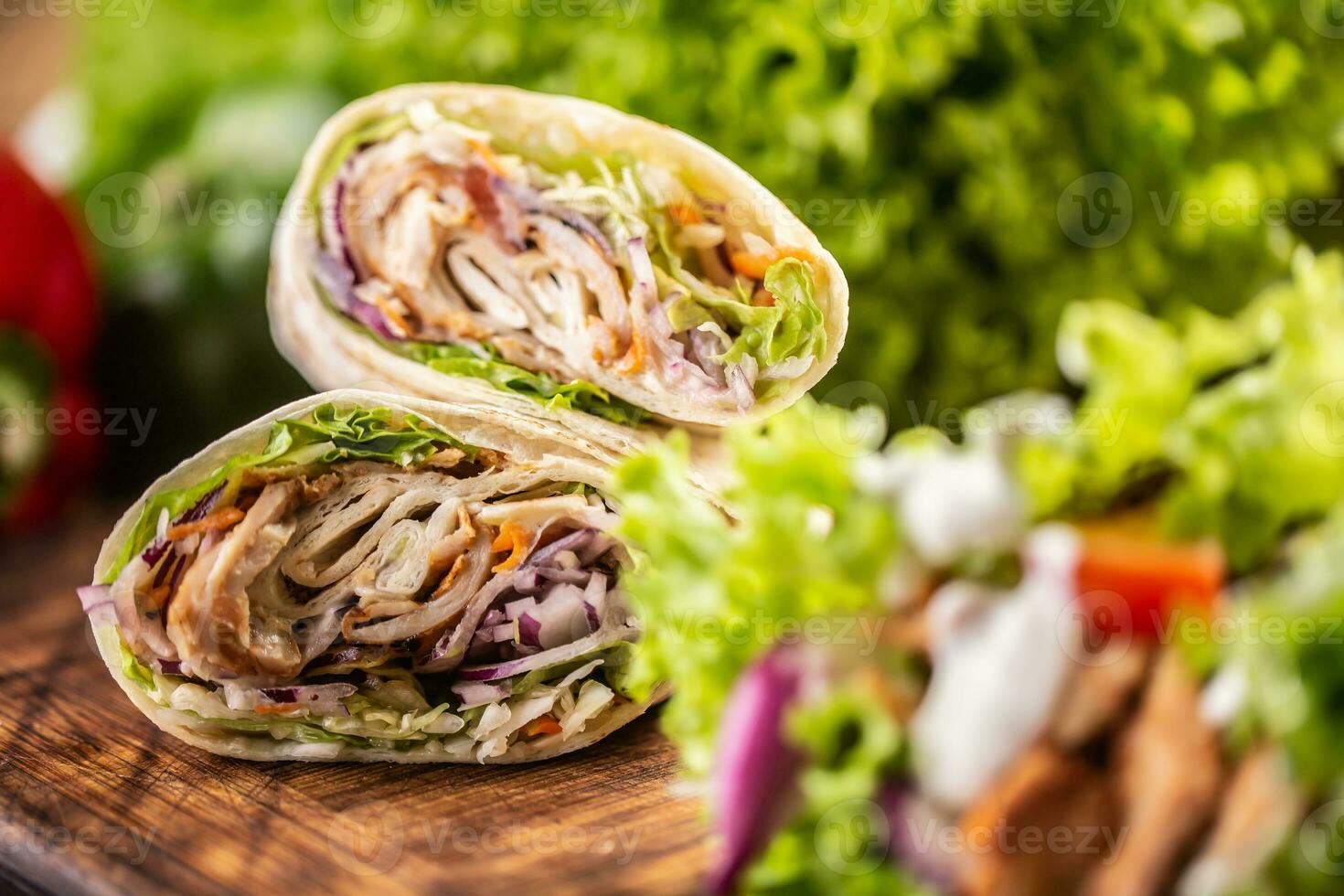 tortilla envoltórios com carne, vegetais, maionese com uma salada em a lado foto