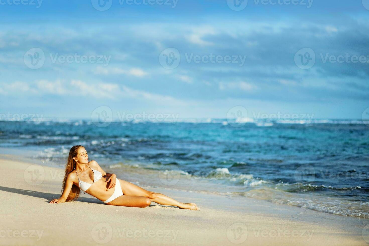 uma mulher dentro uma branco chapéu e bikini em a de praia foto