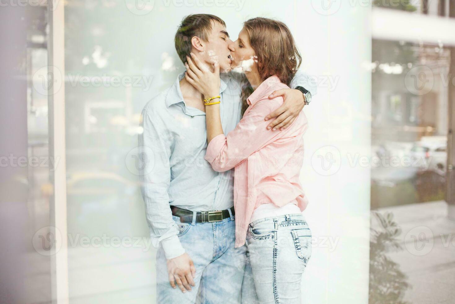 jovem casal se beijando dentro frente do janela foto