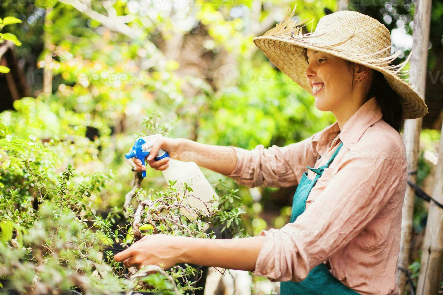 uma mulher rega plantas dentro uma jardim foto