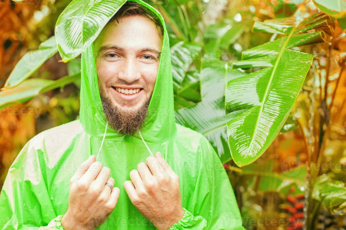 uma homem vestindo uma verde capa de chuva dentro a selva foto