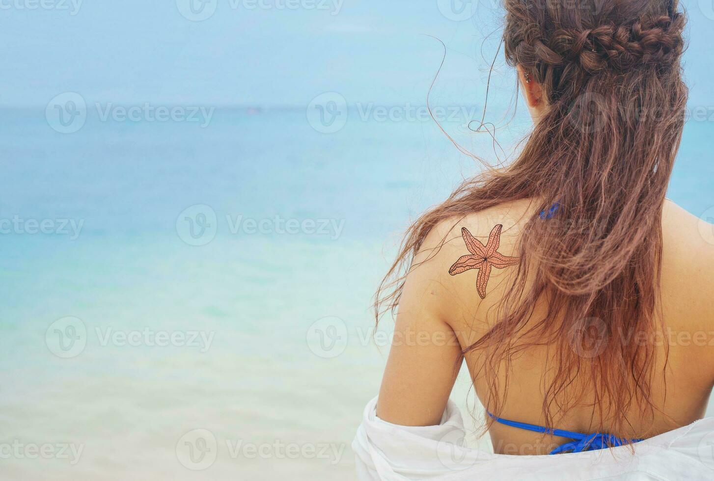 uma mulher com uma estrelas do mar tatuagem em dela costas foto