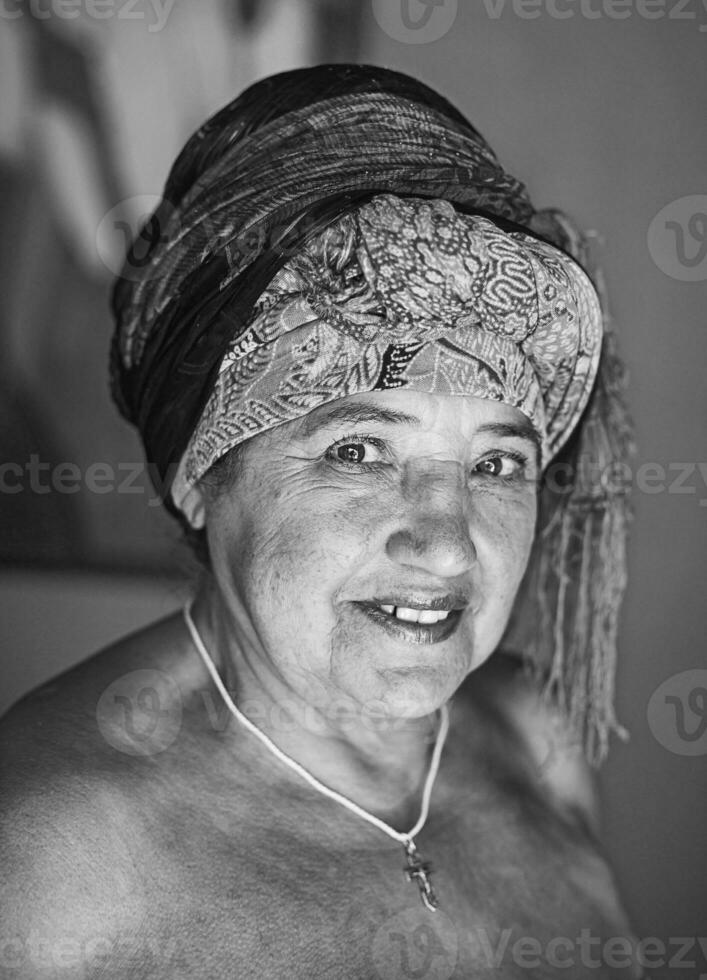 a velho mulher com uma cabeça cachecol em foto