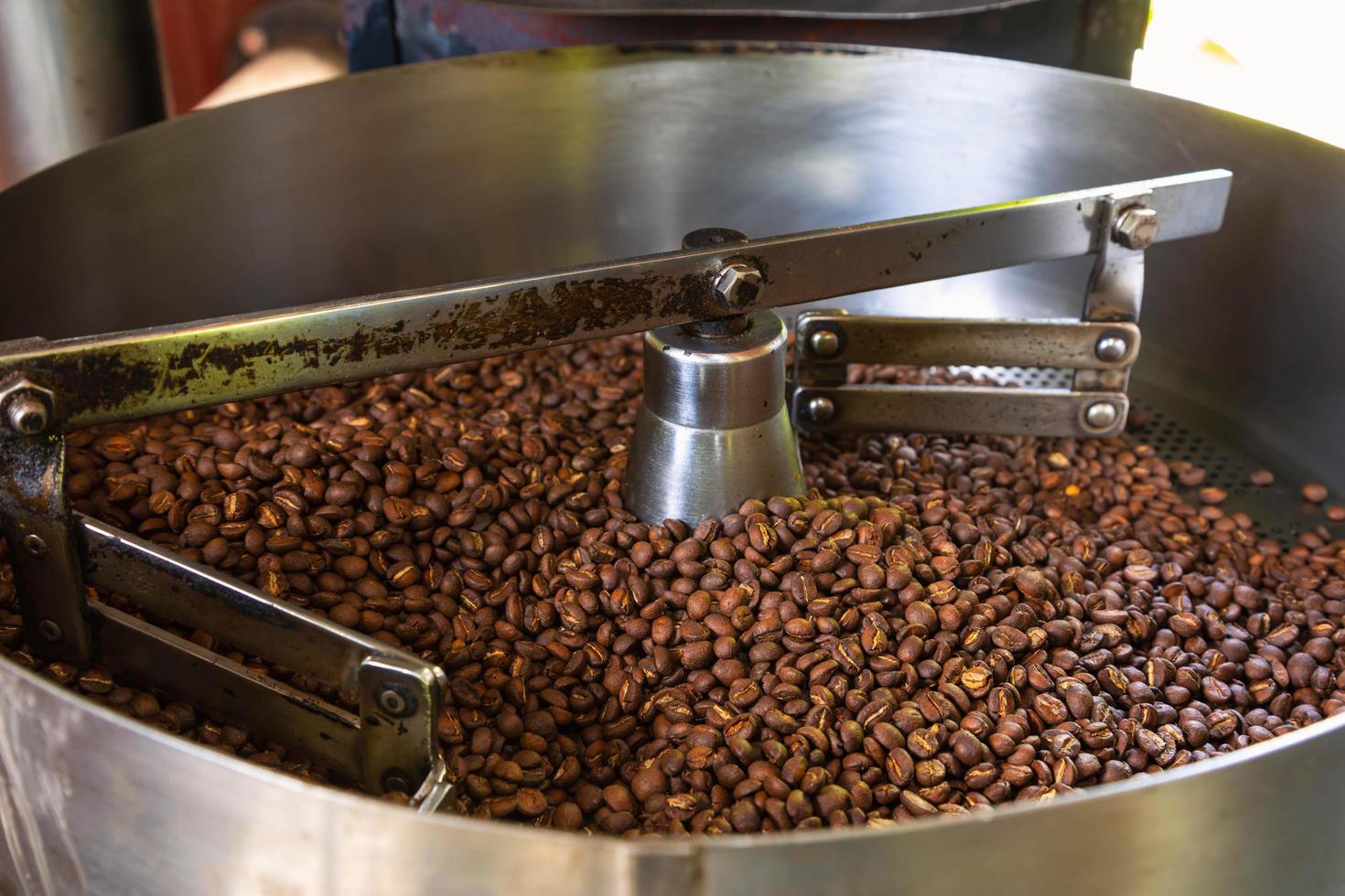 grãos de café em máquinas de torrefação de café foto