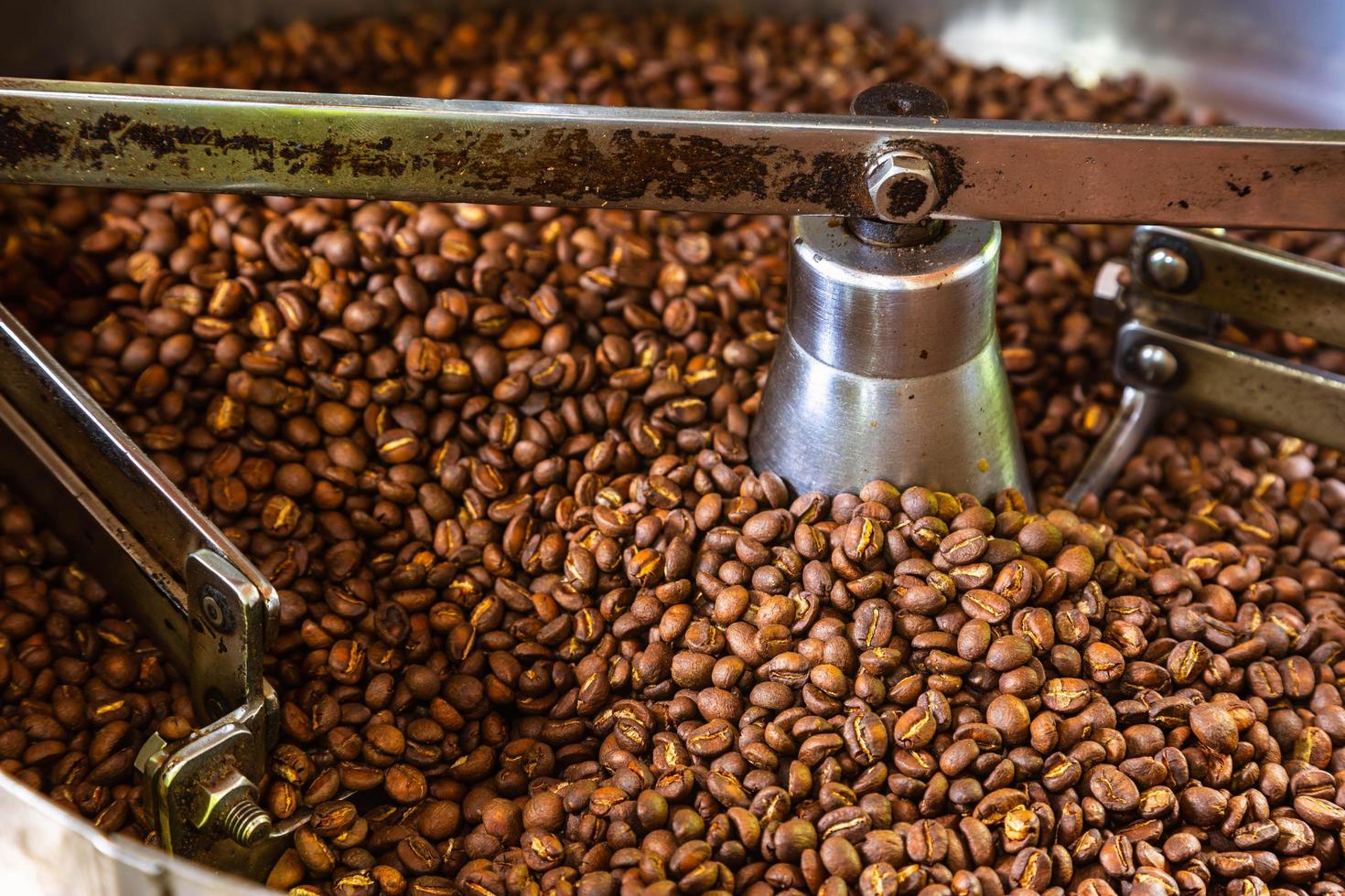 grãos de café em máquinas de torrefação de café foto