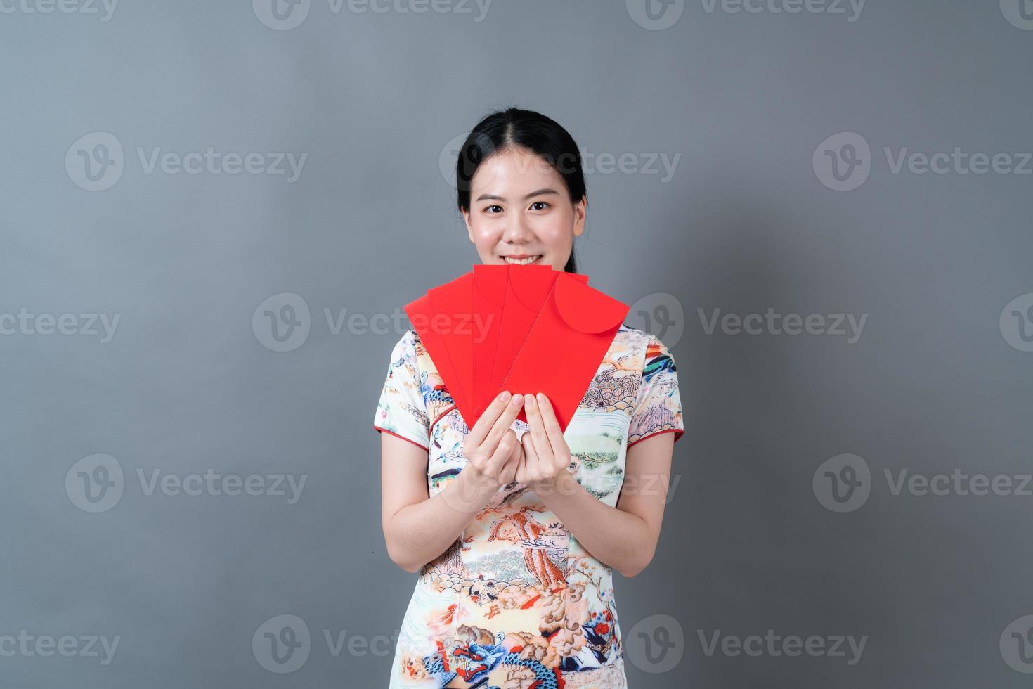 mulher asiática usa vestido tradicional chinês com envelope vermelho ou pacote vermelho foto