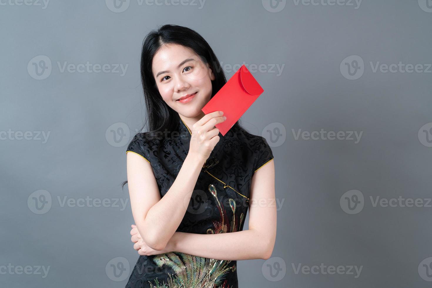 mulher asiática usa vestido tradicional chinês com envelope vermelho ou pacote vermelho foto