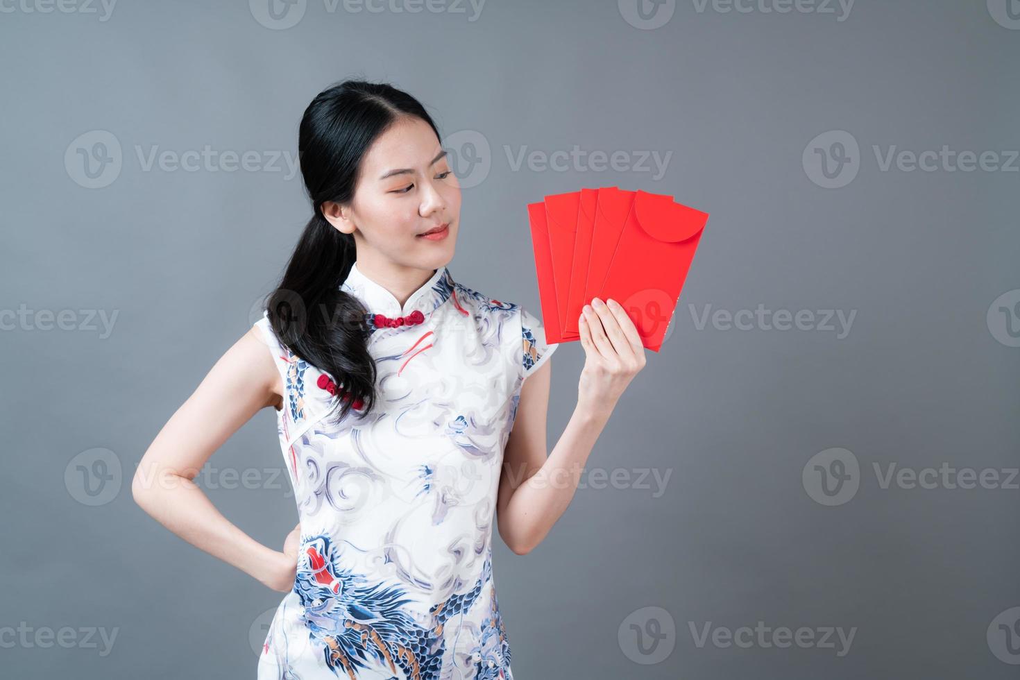 mulher asiática usa vestido tradicional chinês com envelope vermelho ou pacote vermelho foto