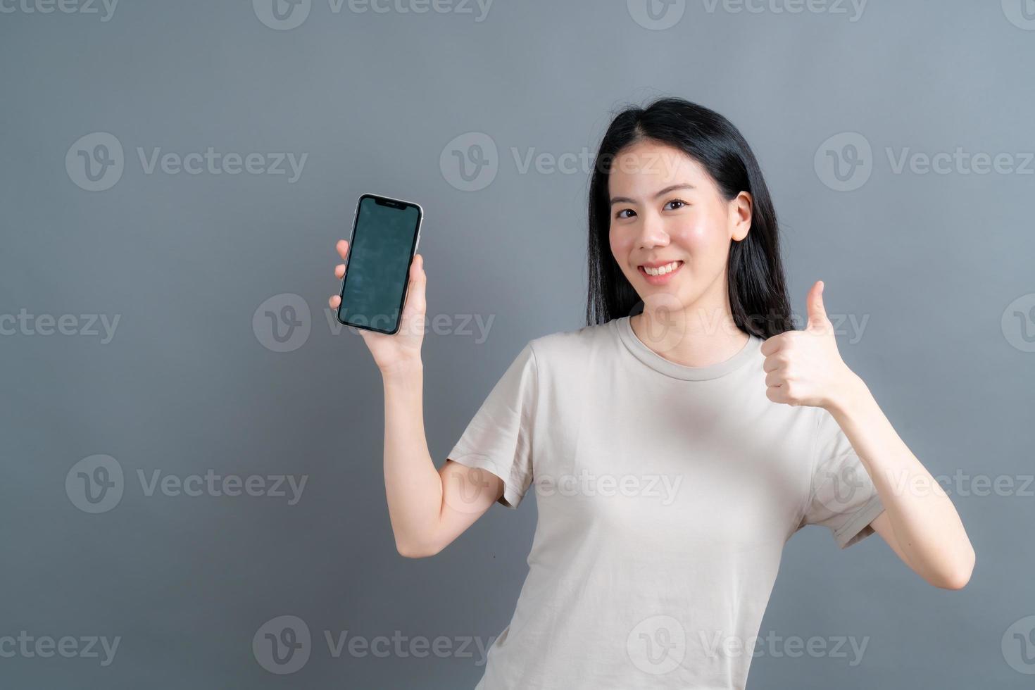 mulher asiática usando aplicativos para celular, se comunicando à distância on-line em uma rede social ou fazendo compras foto