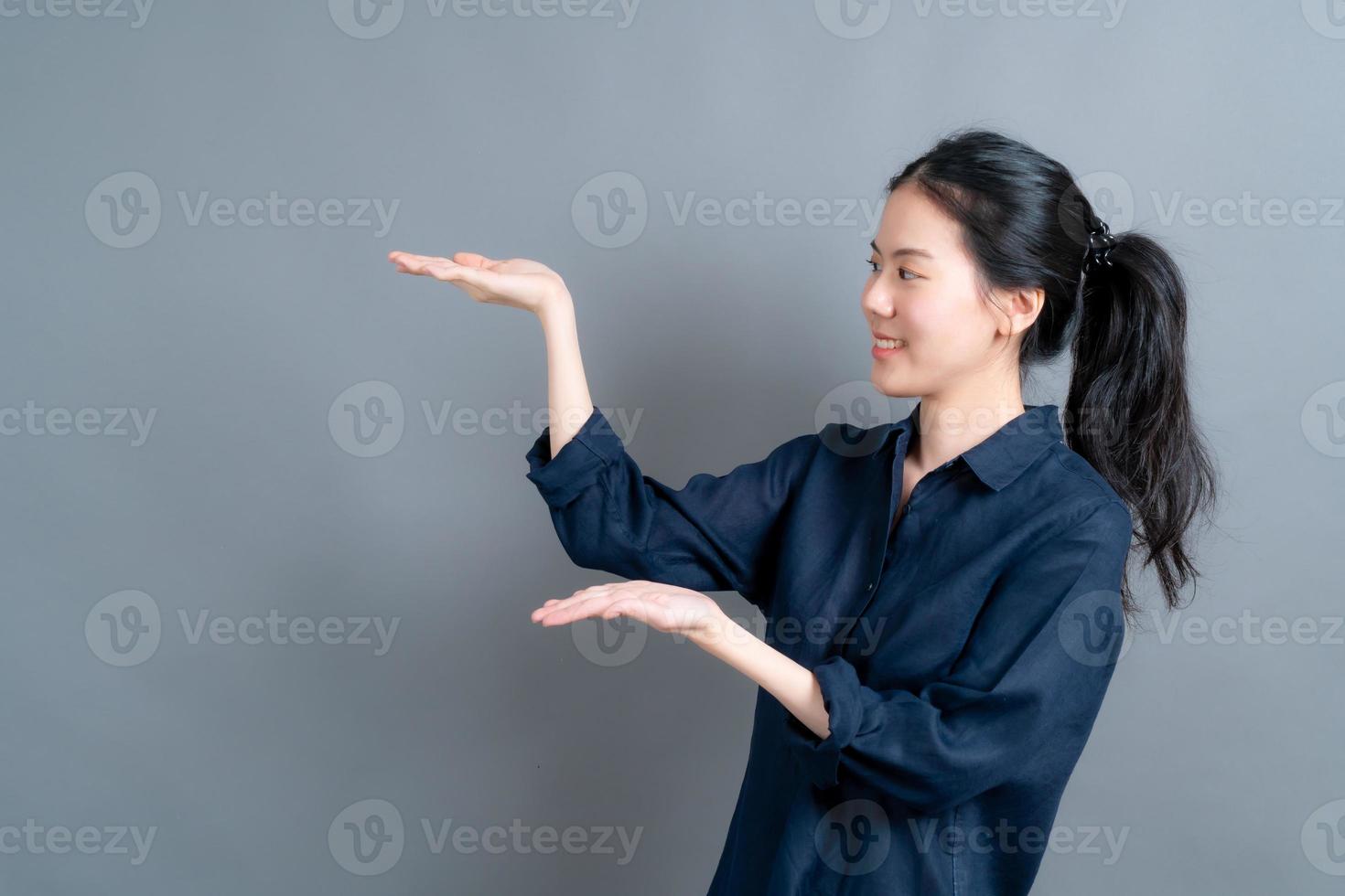 mulher asiática com mão apresentando-se de lado foto