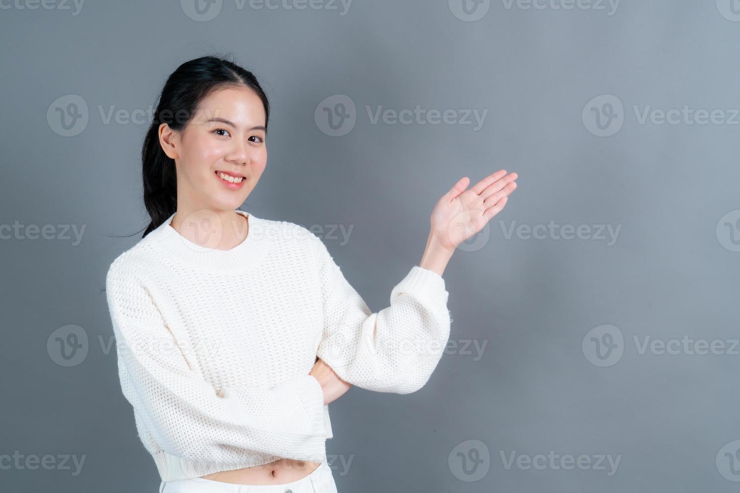 mulher asiática com mão apresentando-se de lado foto