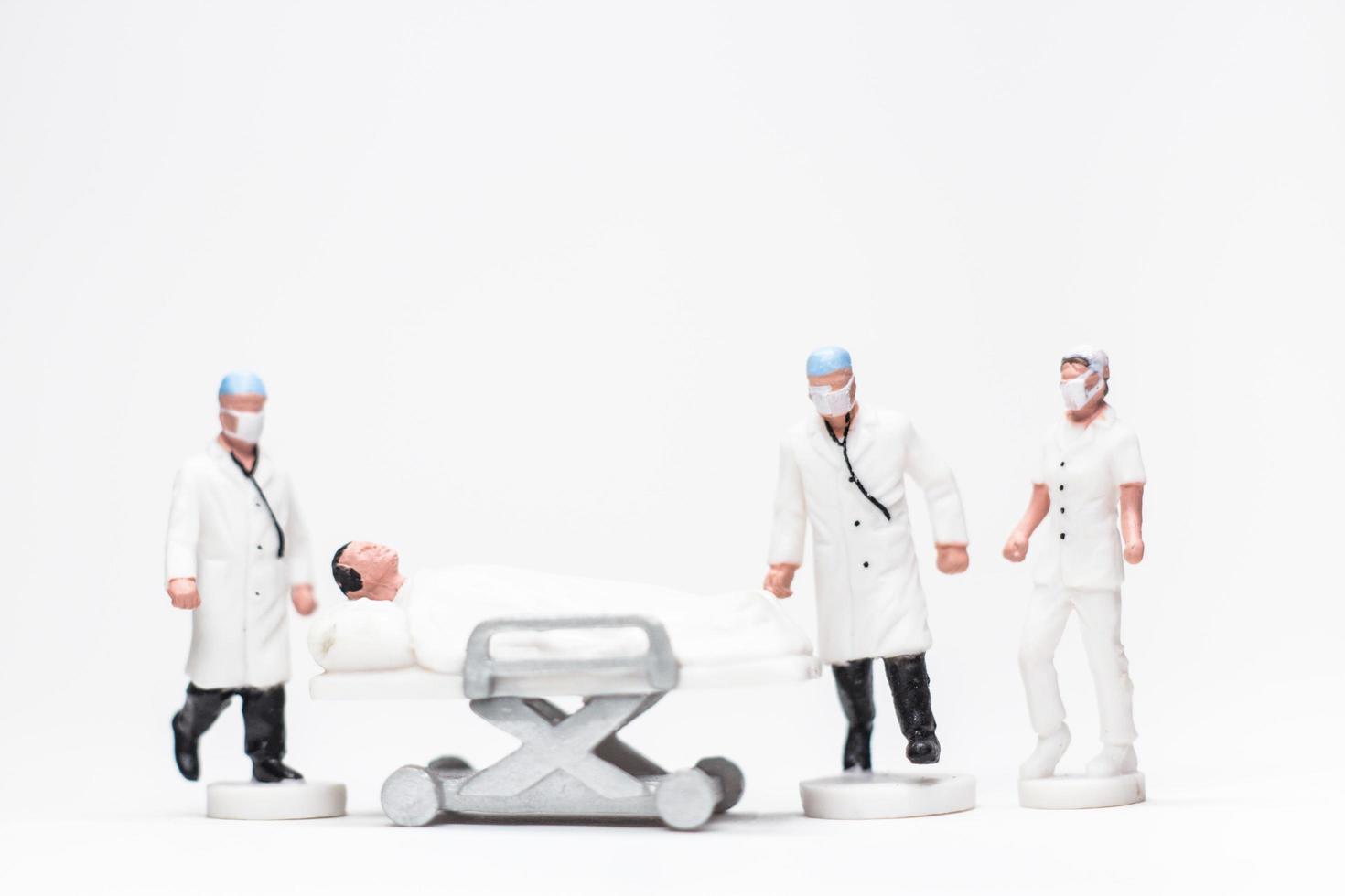 foto conceitual simples, miniaturas de médicos e enfermeiras, miniaturas de evacuação de pacientes infectados