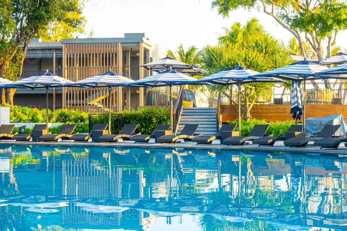 guarda-sol e cama ao redor da piscina externa em hotel resort para viagens de férias foto