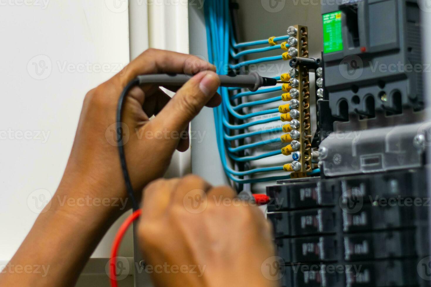 eletricista trabalhos testador medindo Voltagem e atual do poder elétrico linha dentro elétrico gabinete ao controle, profissional homem usa ferramenta comissionamento teste ou verificação o circuito para proteção sistema. foto