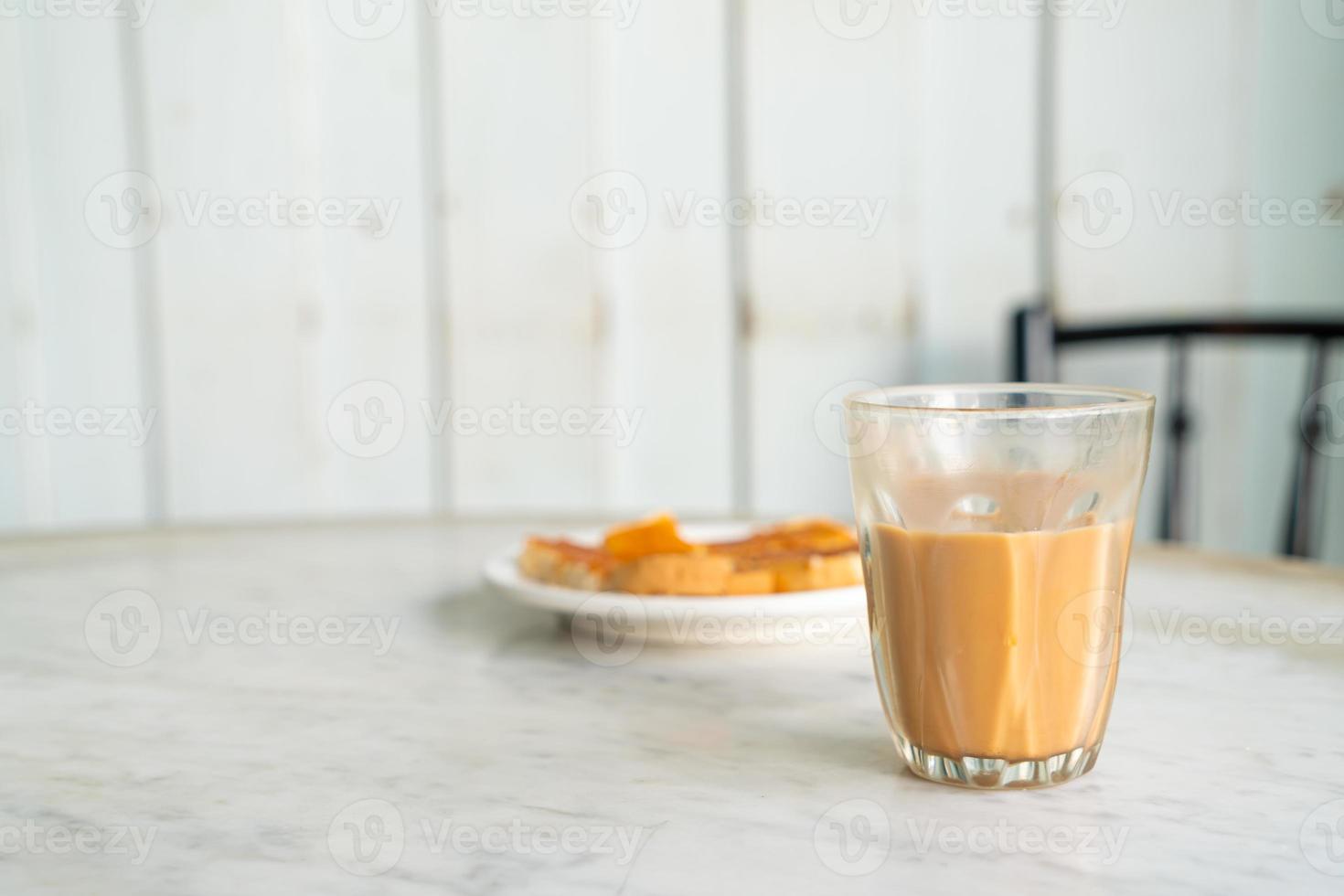 copo de chá com leite tailandês quente na mesa foto