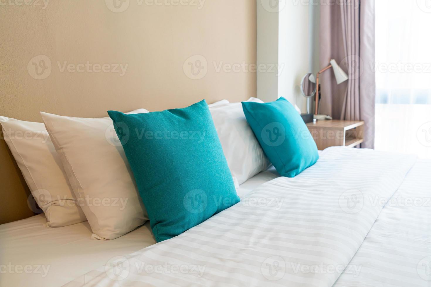 linda e confortável decoração de travesseiros na cama no quarto foto