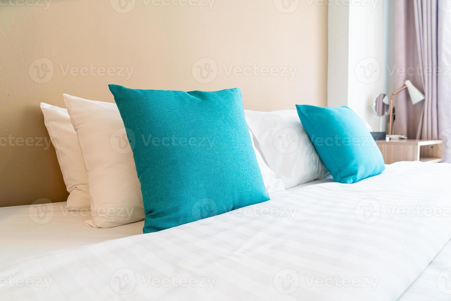linda e confortável decoração de travesseiros na cama no quarto foto