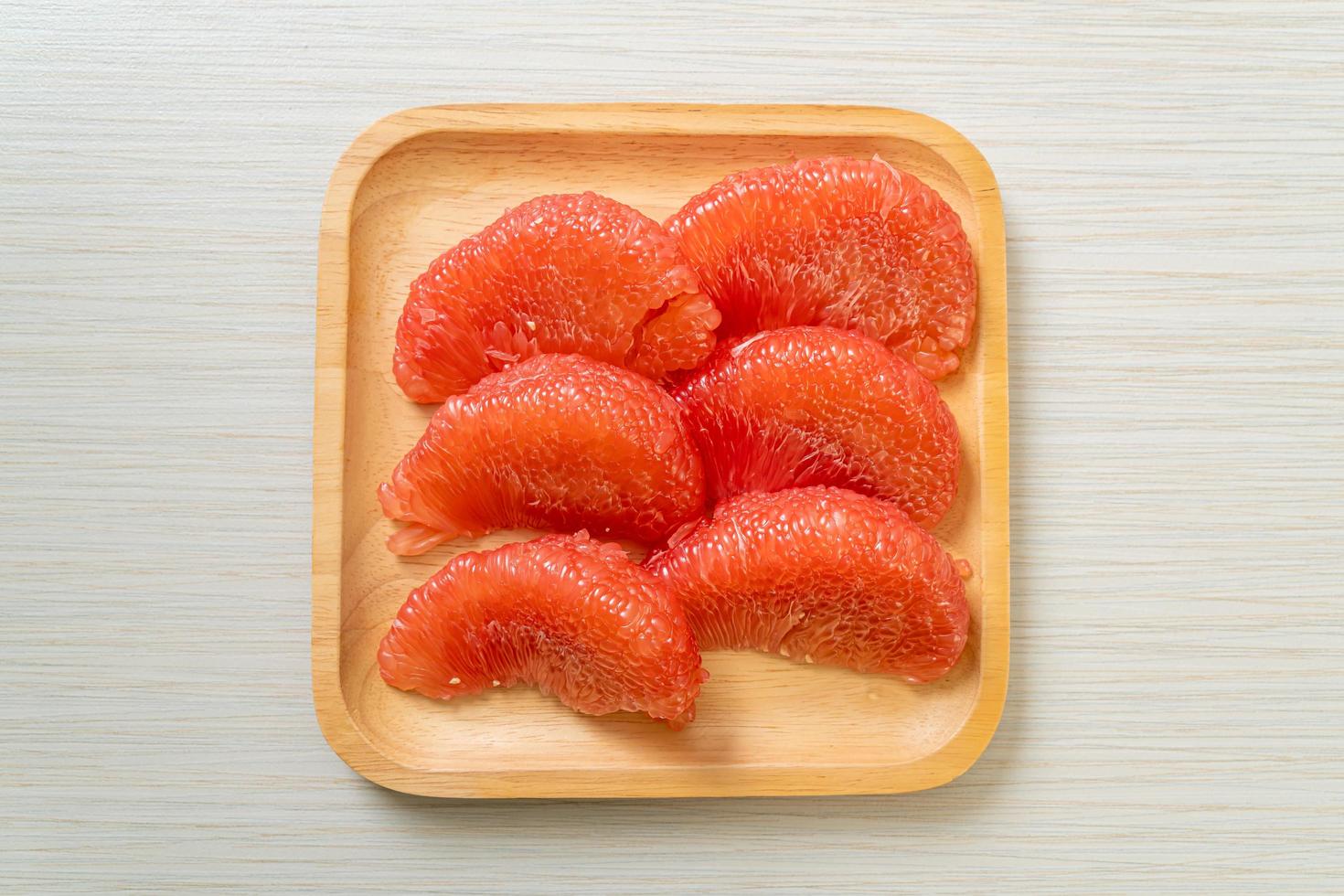 pomelo vermelho fresco ou toranja no prato foto