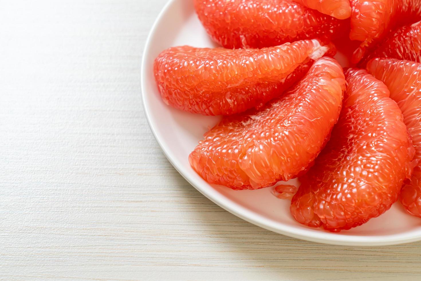 pomelo vermelho fresco ou toranja no prato foto