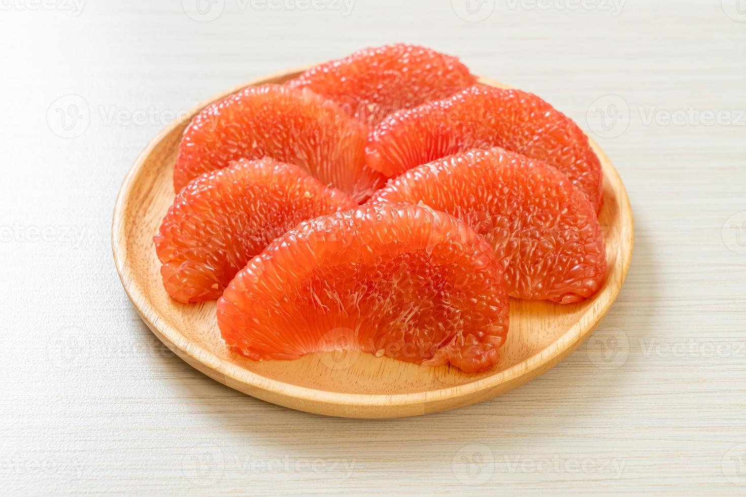 pomelo vermelho fresco ou toranja no prato foto