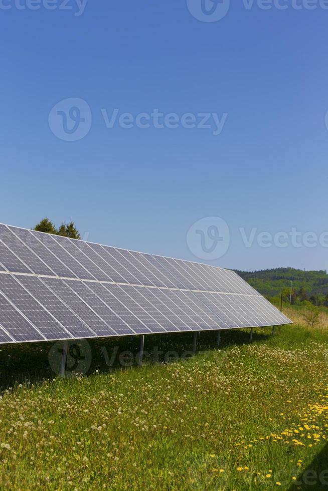 estação de energia solar no prado florido de verão foto