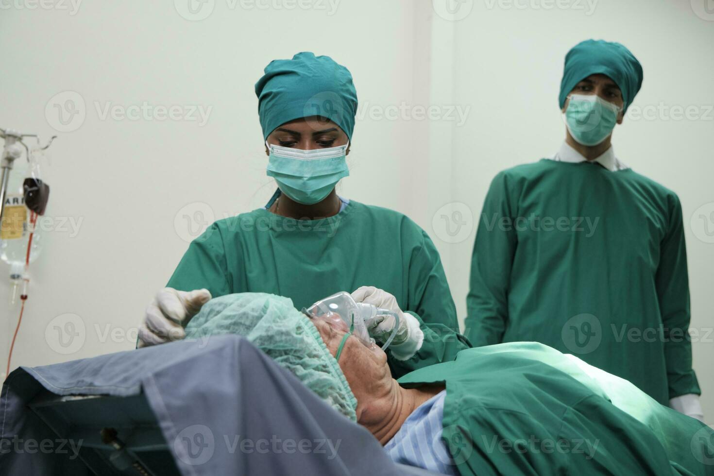 Preto unidade de Terapia Intensiva fêmea médico e praticantes vida resgate coma masculino paciente com ventilador depois de cirurgia crítico ressuscitação e médico Operação dentro hospital emergência sala. foto