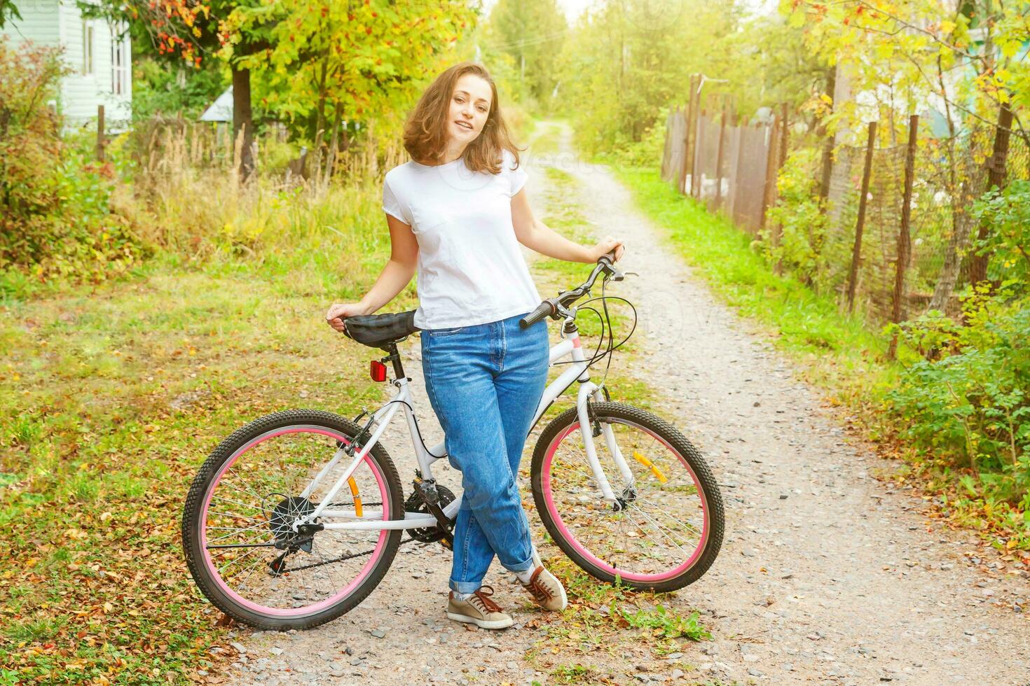 jovem andando de bicicleta no parque da cidade de verão ao ar livre. pessoas ativas. garota hipster relaxa e motociclista. ciclismo para trabalhar no dia de verão. conceito de estilo de vida de bicicleta e ecologia. foto