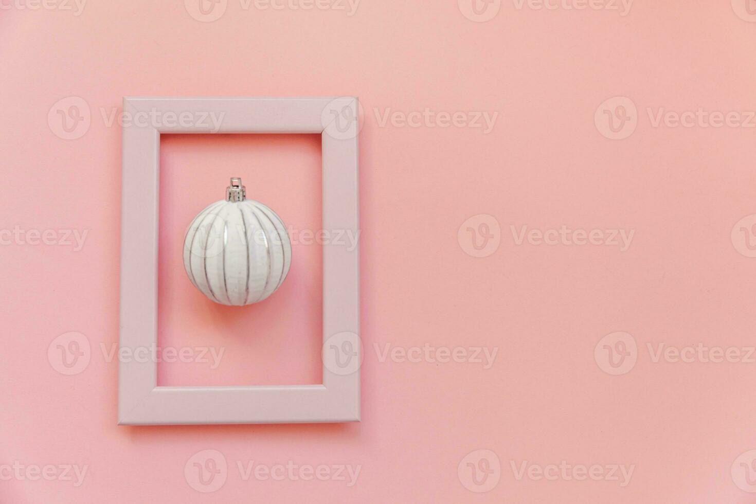 simplesmente mínimo composição inverno objetos enfeite bola dentro Rosa quadro, Armação isolado em Rosa pastel na moda fundo foto