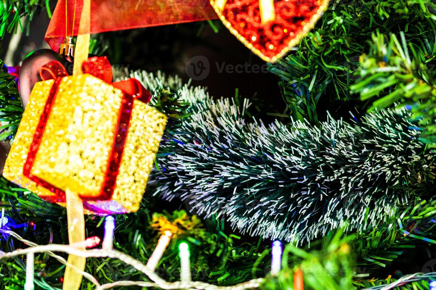 enfeites de natal pendurados em pinheiro foto